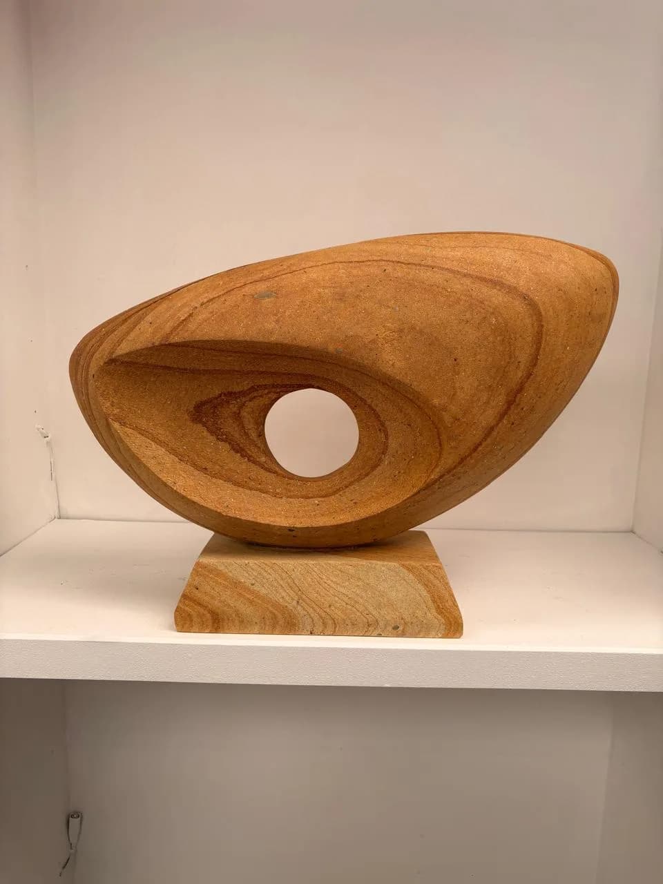 Limestone Sculpture #2 by Omar Yepez, wide abstract carved limestone form with a central circular opening at El Dorado Gallery