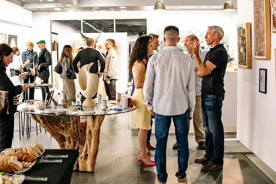 Guests gathered among paintings and sculpture during an evening event at El Dorado Gallery